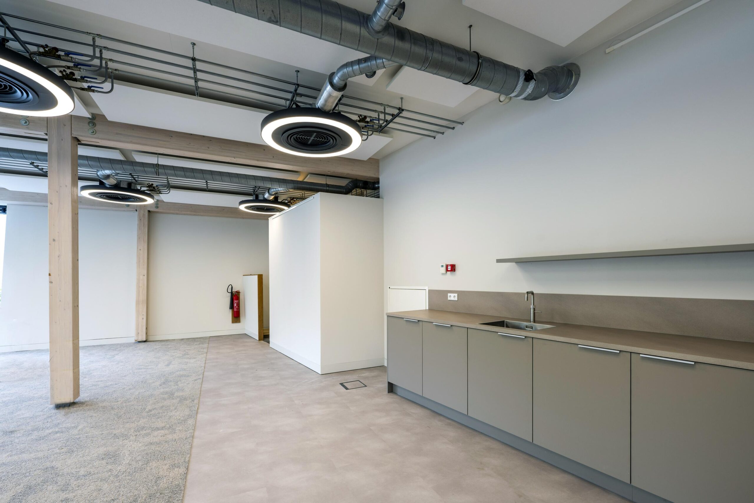 Modern kantoorpand aan de Fred. Roeskestraat met een open ruimte, industriële plafonddetails en een kitchenette.